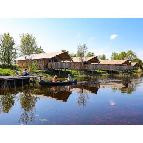 Lovely glamping tent with a kitchen and bathroom, located near a pond